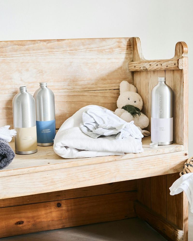 Soap bottles and folded linen on a wooden bench