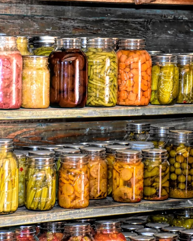 Wooden shelves lined with jars of preserved vegetables